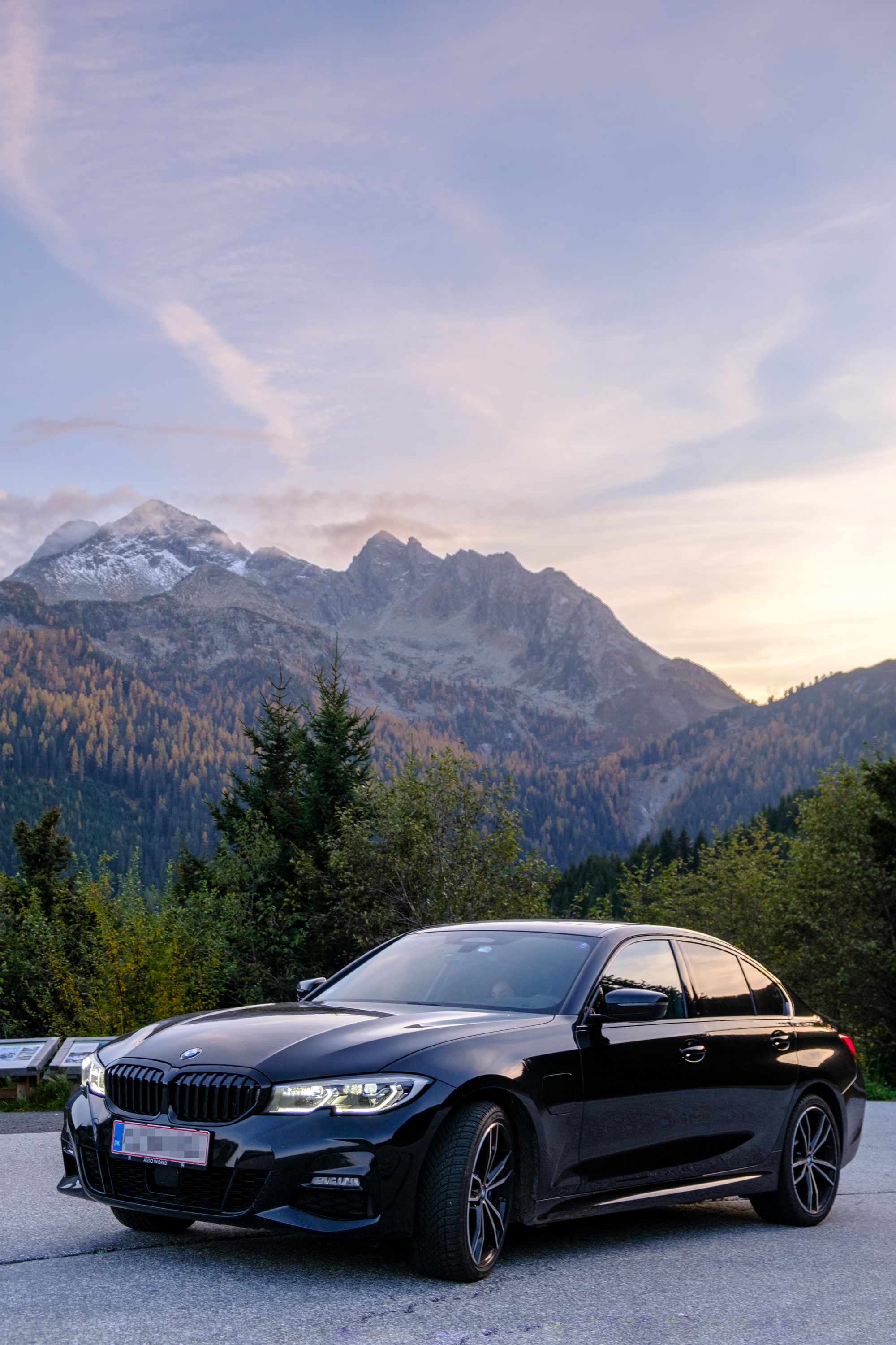 Our car with on a background of Austrian Alps during sunset, road trip autumn 2022
