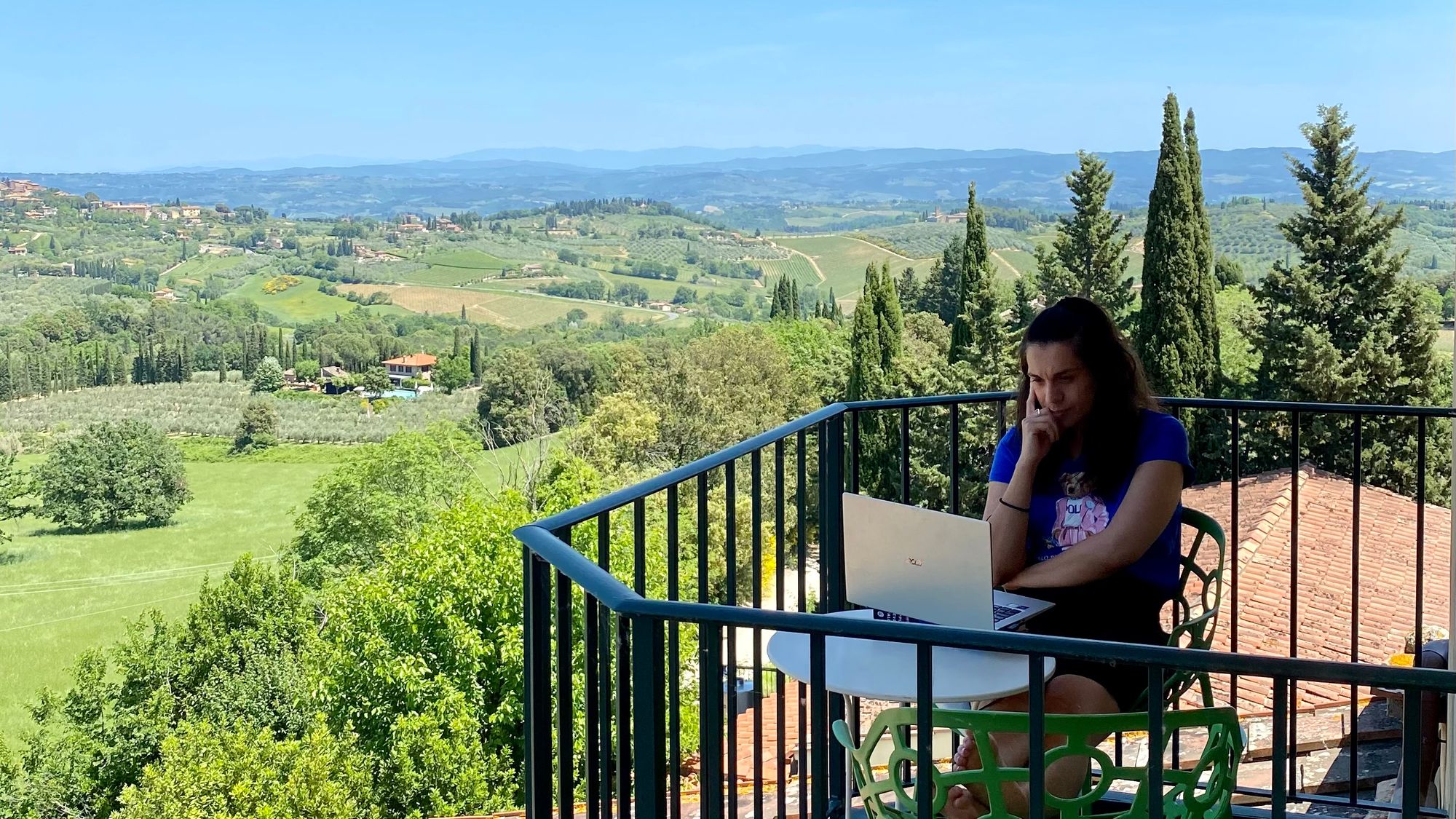 Working on the balcony with the views of San Gimignano and the Tuscan landscape in the background