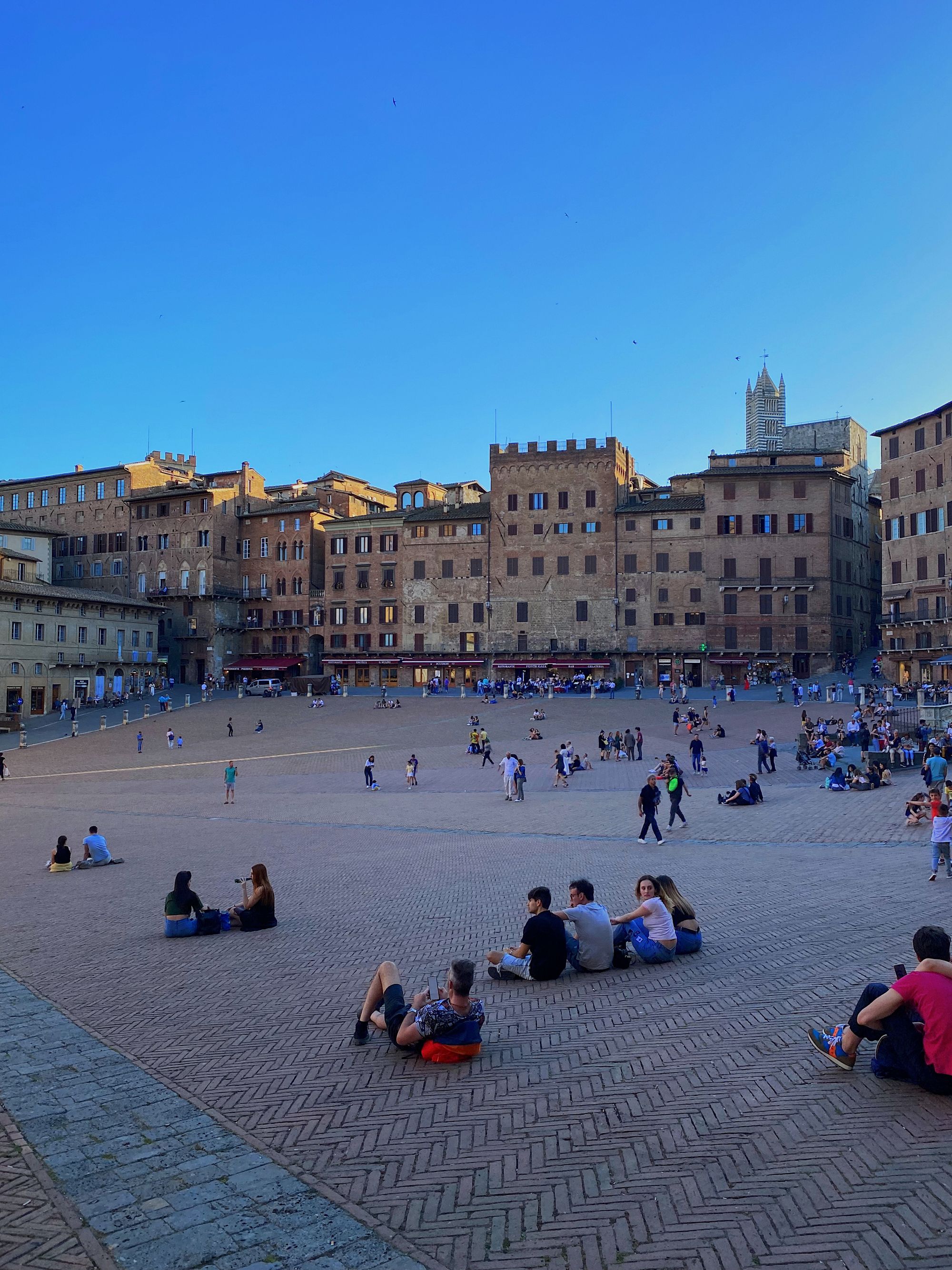 People resting in the beautiful Piazza del Campo, Siena