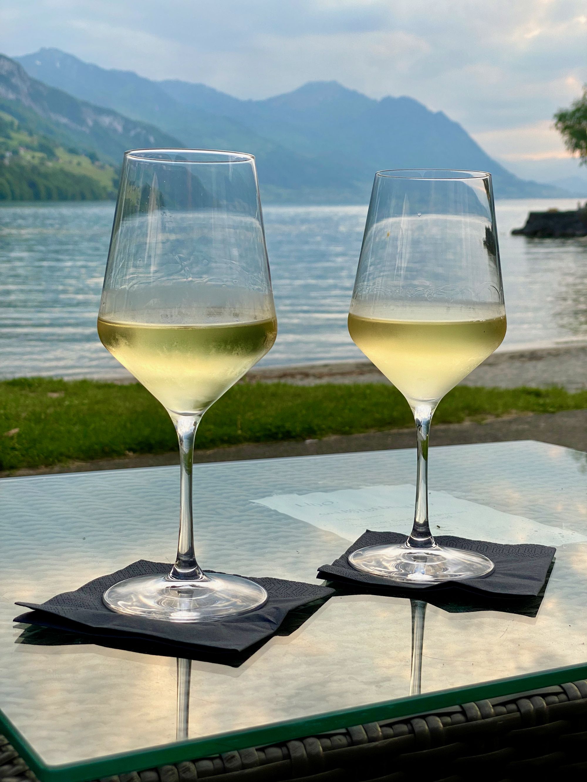 Sunset over lake Lucerne with two glasses on wine in front