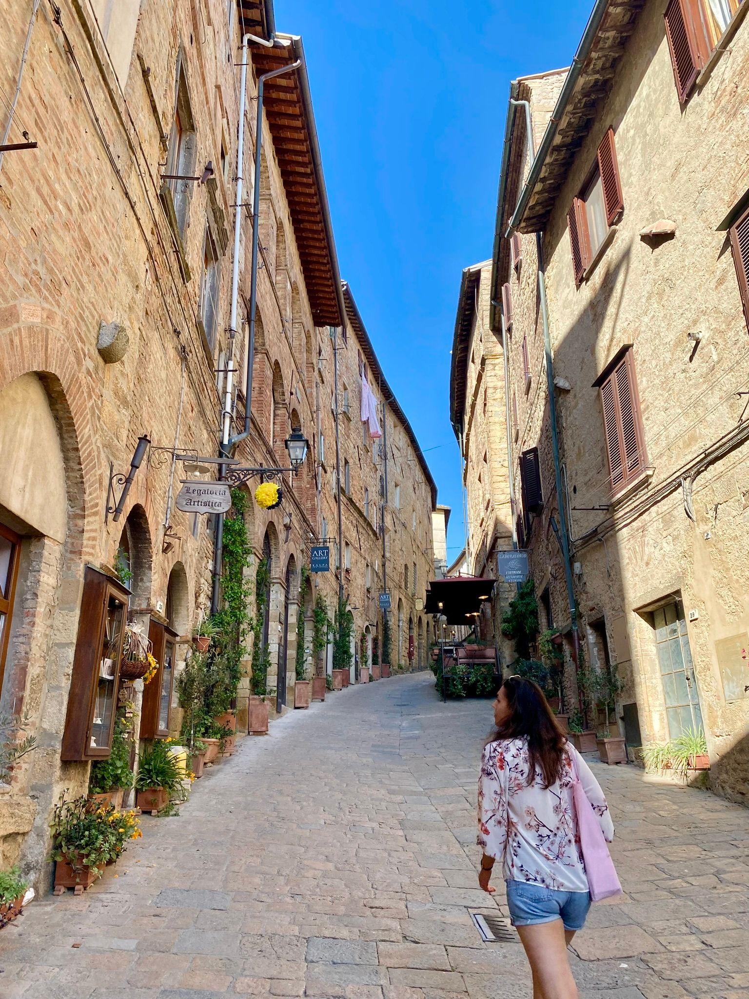 Silvia exploring an seemingly empty hilltop town in tuscany