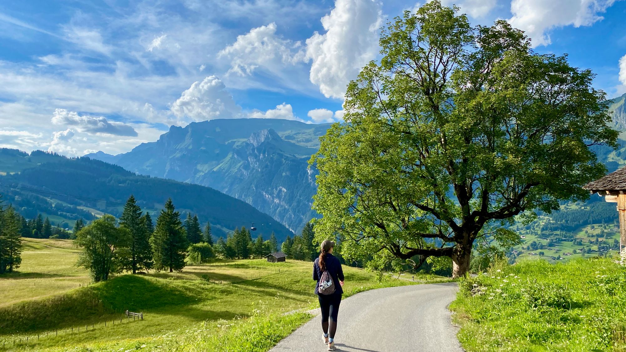 Silvia walking on a trail approaching some village